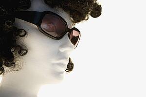 Mannequin with curly brown wig and sunglasses