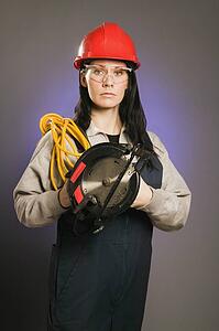 Tradeswoman holding an extension cord and a power saw