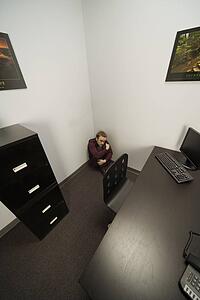 Man hiding in office corner