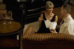 Couple eating take out in the living room
