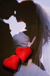 Two red hearts on photograph of wedding couple