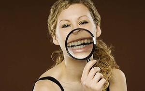 Woman with magnifying glass over her mouth