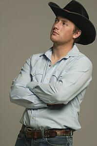 Young man wearing western wear with arms crossed