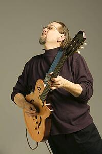Middle aged man playing guitar looking upwards
