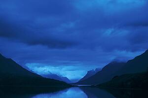 Mountains with dark cloud cover over a lake