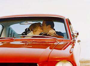 Couple kissing in antique car