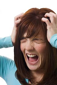 Woman holding head in anguish