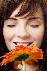 Women enjoying smell of flower