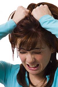 Woman holding head in anguish