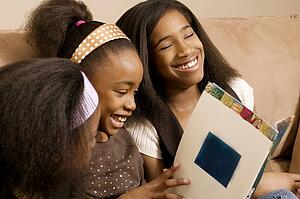 Girls reading and laughing together