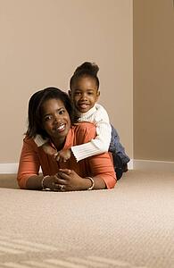 Woman and girl cuddling on the floor