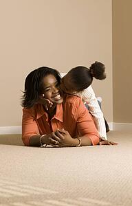 Mom and daughter cuddling on the floor