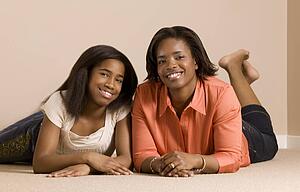 Mother and daughter laying on the floor smiling and posing