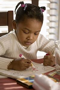 Little girl coloring a picture at the table