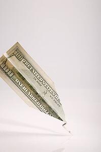 One hundred American dollar bill folded into paper airplane