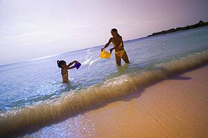 Mother and daughter playing in ocean 