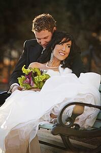Newly married couple sitting on a bench
