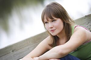 Young woman sitting, looking away