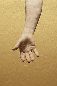 A person's hand with yellow wall