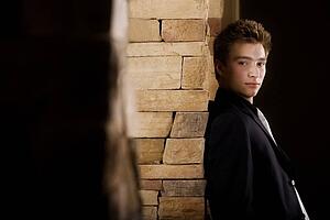 Side view of a man standing by wall