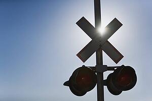 Railroad crossing lights with sun glare