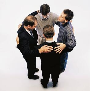 High angle view of men praying and standing in a circle