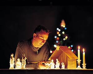 Man with nativity scene figurines and lights