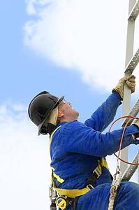 Industry worker climbing a ladder