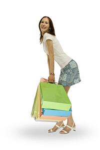 Side view of a woman smiling and holding shopping bags