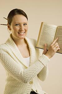 A woman smiling and showing Bible