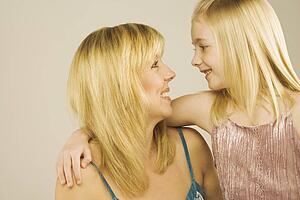Portrait of a mother and young daughter looking at one another