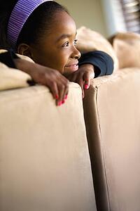 Girl looking over the back of couch