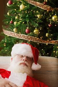 Santa Claus, asleep in front of Christmas tree
