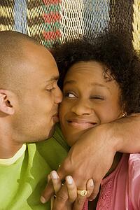 Man hugging and kissing woman