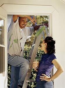 Man taking a break from painting the outside of his house