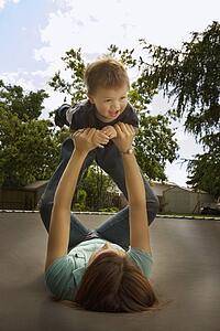 Mother playing with son on trampoline