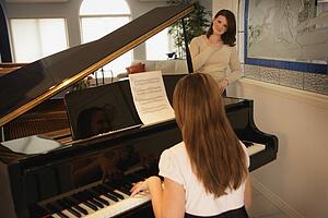 Teenage daughter playing the piano for her mother