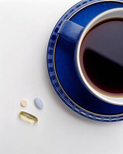 Pills beside a cup of coffee