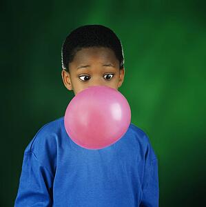 Boy blowing huge bubble with bubble gum