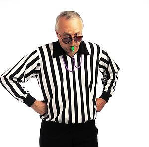 Referee with hands on hips blowing a whistle