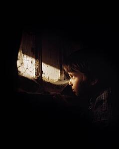 Girl looking out window and crying