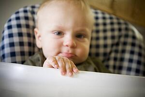 Baby boy pouting in highchair