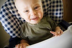 Baby boy crying in highchair