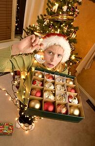 Teenage girl tangled in christmas lights holding decorations