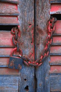 Padlock and chain on wooden door