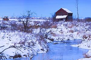 Abandoned shack near frozen winter creek 