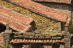 Stone cross on lintel with pantiled roofs, Carmona, Cantabria, Northern Spain