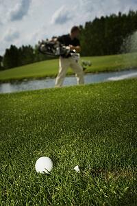 Golf ball and golfer in background