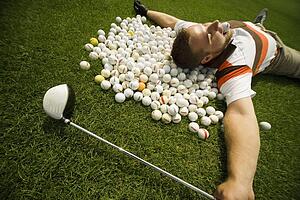 A man lying on golf balls