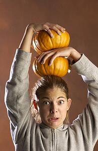 Girl playing with pumpkins 